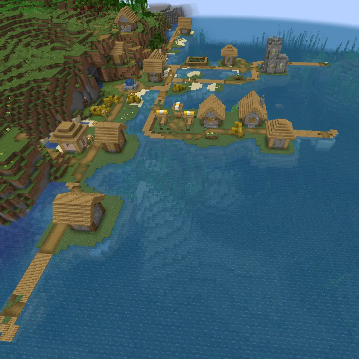 An aerial view of a Minecraft plains village built out over a lukewarm ocean, with houses on small islands joined by wooden paths and piers and a tall stone building at the far end