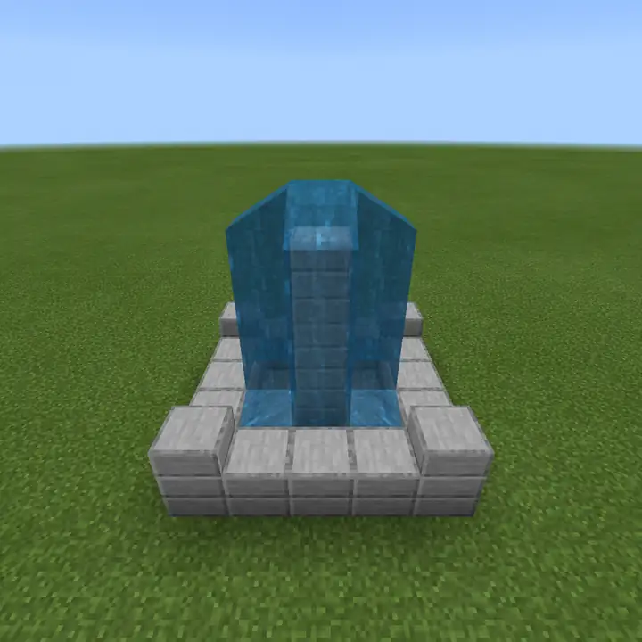 A small Minecraft fountain of stone bricks with a column of water pouring down all four sides into the basin, standing alone on flat grass under a pale blue sky